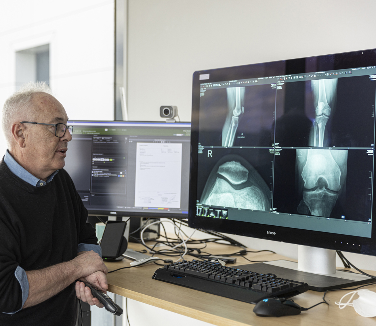 A radiologist sitting in front of a computer looking at x-ray images